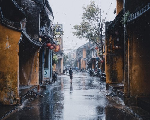 Person walking along a quiet city street near traditional architecture